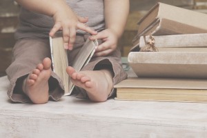 Small feet of a child watching a book